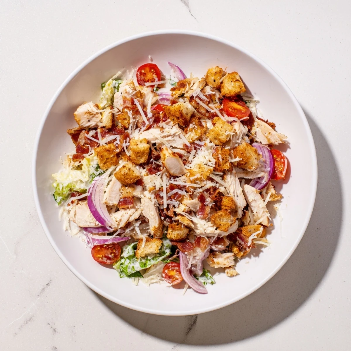 Costco Chicken Bake Salad Bowl with tender chicken, crispy bacon, and creamy Caesar dressing, ready to enjoy.