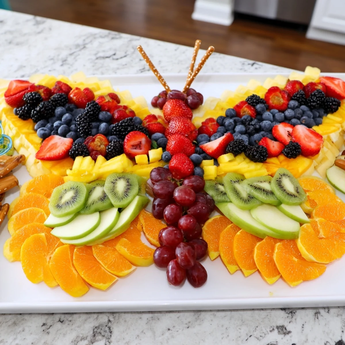 A delightful platter of Monarch Magic Fruit Butterfly, crafted with colorful fruit pieces and pretzel antennae.