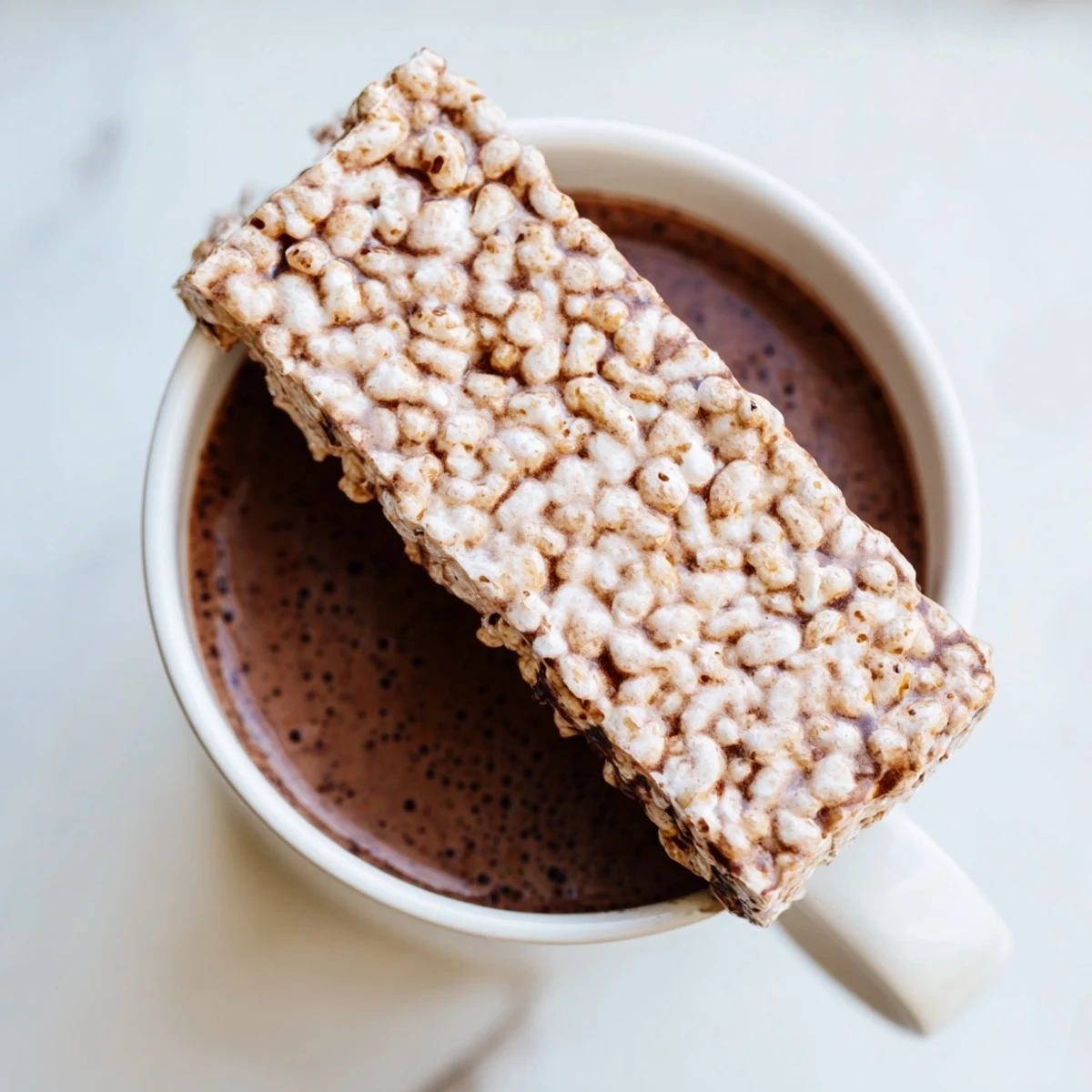 Steaming hot chocolate in mugs, topped with a cozy Bear Marshmallow Bar, ready to melt.