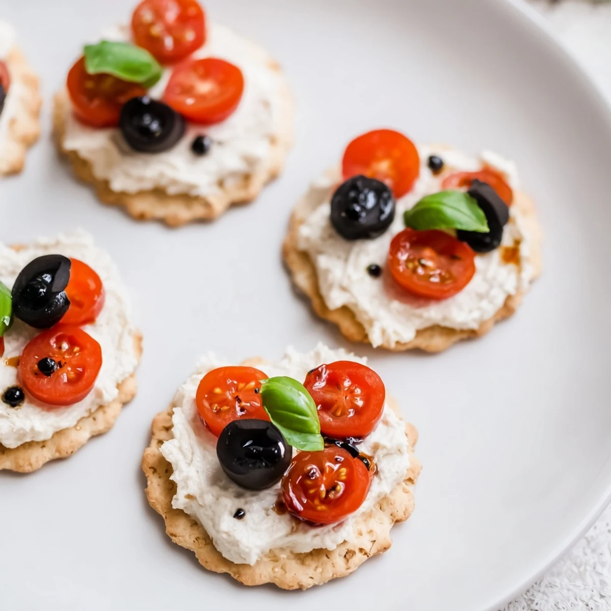 Freshly made Ladybug Tomato & Olive Bites featuring juicy tomatoes, salty olives, and basil, perfect as appetizers.