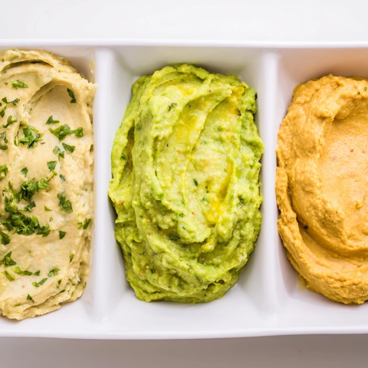 A colorful Dip Trio: three vibrant dips, perfect with pita chips for your appetizer.