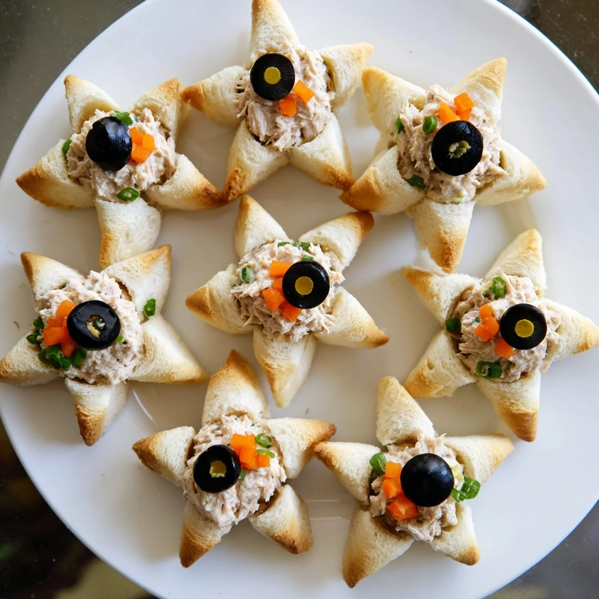 Freshly made Mini Starfish Sandwiches, garnished with olives, capers, and carrot, ready to serve.
