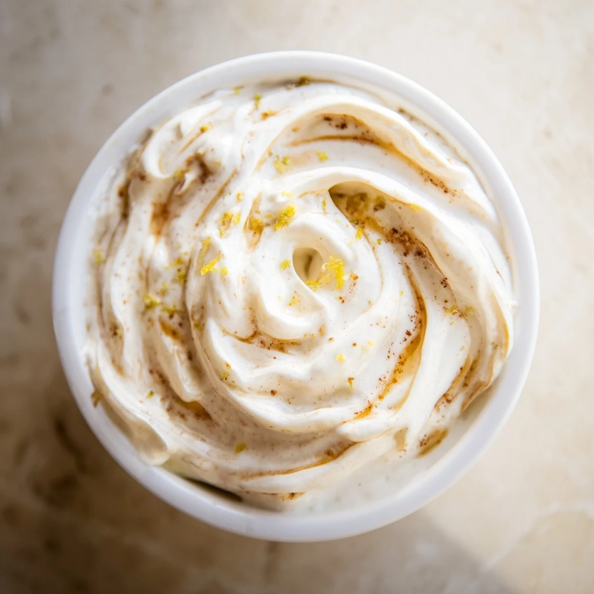 A bowl of refreshing Greek Yogurt Fruit Dip next to colorful, juicy apple slices and grapes.