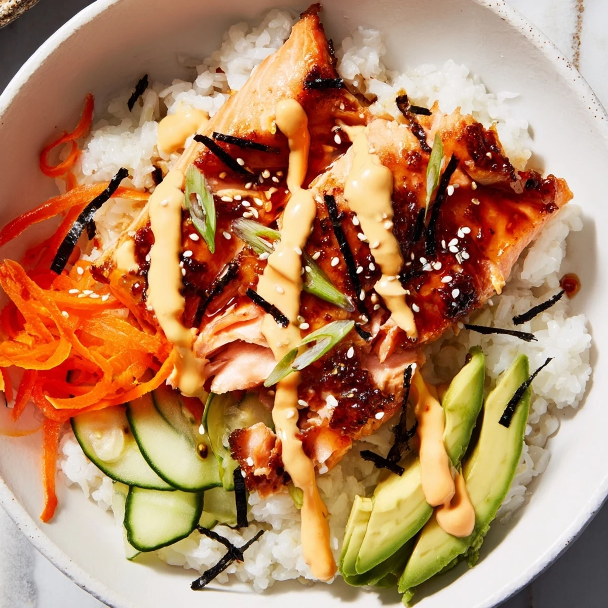 A close-up of a delicious teriyaki salmon rice bowl, showing glazed salmon atop fluffy rice.