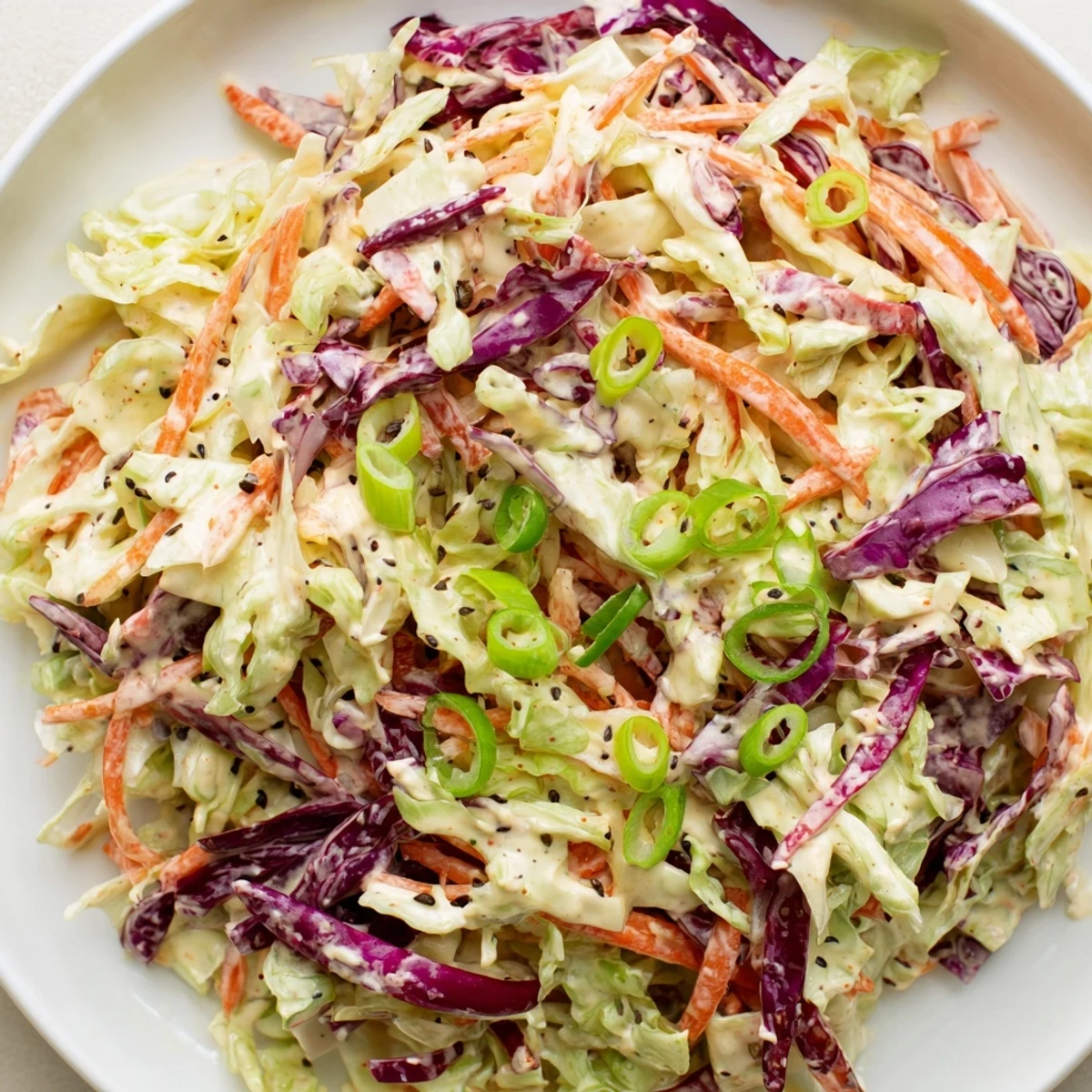 Quick Coleslaw Salad with Creamy Dressing: a vibrant mix of shredded cabbages and carrots, coated in creamy dressing.