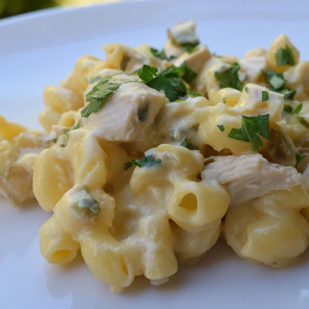 Hearty skillet of Green Chili Chicken Mac featuring tender pasta shells coated in a rich, cheesy sauce with mild green chiles and juicy chicken pieces.
