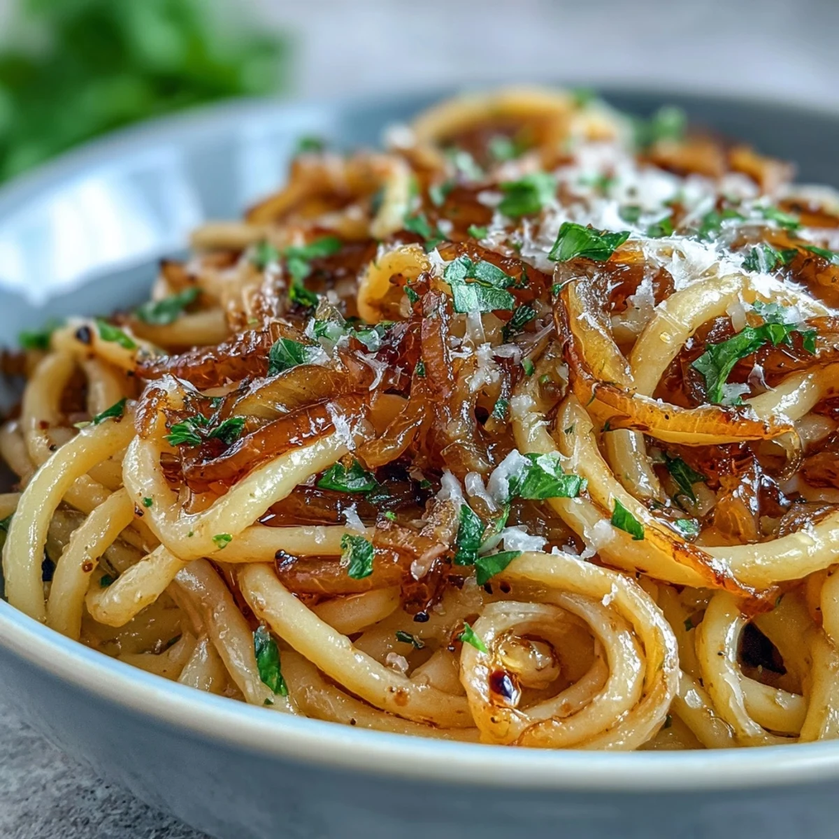 Close-up of Caramelized Onion Pasta with chili oil drizzle and vibrant red chili flakes.