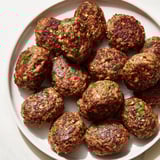 Succulent, flavorful Turkish Köfte meatballs served with a vibrant tomato salad for a delicious meal.