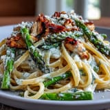 Creamy Asiago Chicken & Asparagus Pasta served warm in a bowl with fresh parsley garnish.