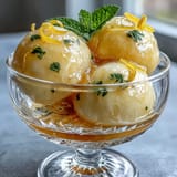 Vibrant limoncello sorbet in chilled glasses, garnished with fresh mint and lemon zest for a refreshing summer dessert.