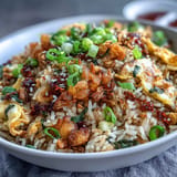 Flavorful Asian fusion egg fried rice tossed with chili crisp, soy sauce, and sesame oil for a spicy, savory twist.  