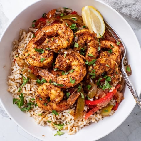 Succulent spicy Cajun shrimp and rice with vibrant peppers, perfect for dinner.