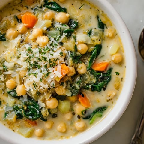 Creamy Tuscan Chickpea and Spinach Soup in savory tomato broth with fresh herbs.  