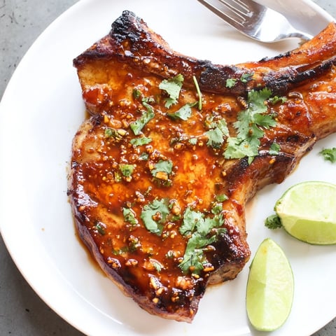 Juicy Chipotle Honey Pork Chops glistening with smoky honey glaze against a vibrant backdrop.  