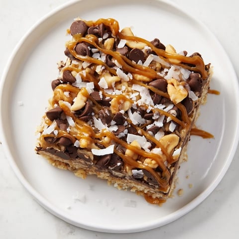 Golden, gooey 7-Layer Magic Bars with salted caramel drizzle on a baking rack, ready to serve.