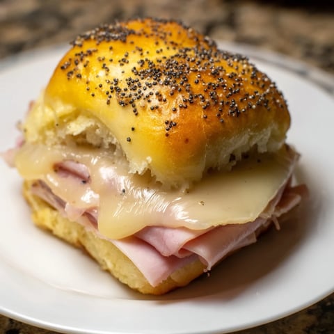 Golden-brown Baked Ham and Cheese Party Sliders, warm and savory, ready for serving with a tangy glaze.