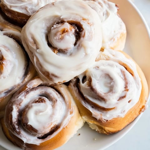 Fluffy, golden brown TikTok Heavy Cream Cinnamon Rolls baking in their pan, ready to be iced.