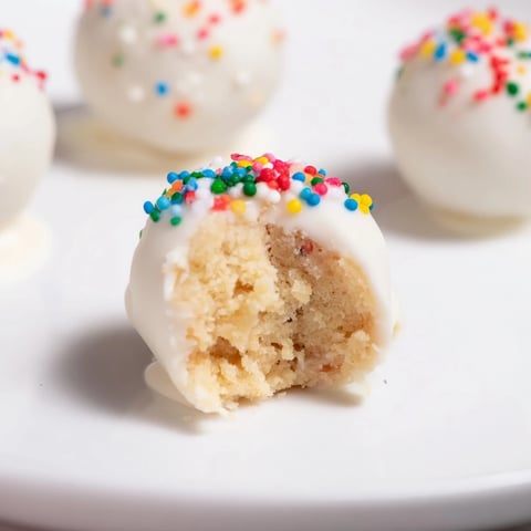 Lightened-Up Sugar Cookie Cake Pops stand tall, a delicious dessert coated in glistening white chocolate and sprinkles.
