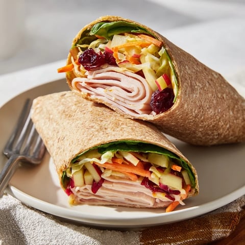 Bright and colorful cranberry apple slaw filling a turkey wrap, ready for an easy lunch.