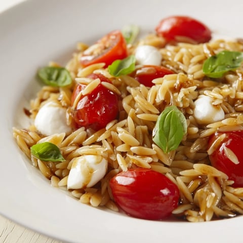 Fresh Caprese Orzo Salad with juicy tomatoes, creamy mozzarella, and basil, ready to enjoy.