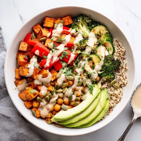 Fluffy quinoa topped with colorful roasted vegetables and creamy tahini dressing for a wholesome Quinoa Buddha Bowl.