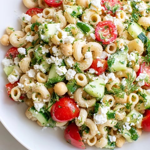Bright chickpea pasta salad with diced cucumber, cherry tomatoes, and fresh herbs, tossed in a zesty lemon vinaigrette.