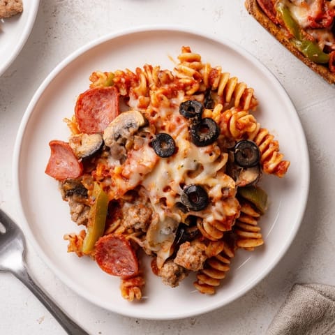 A delicious Pizza Pasta Casserole topped with gooey cheese and savory meats.  
