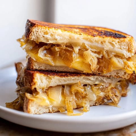 Close-up of a perfectly grilled French onion grilled cheese, hinting at a symphony of savory flavors.