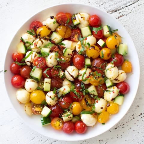 A close-up view of the Simple Holiday Chopped Caprese Salad bursting with flavor and drizzled balsamic glaze.
