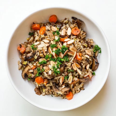 Golden wild rice pilaf with cremini mushrooms, carrots, and celery, topped with toasted almonds for a nutty crunch.