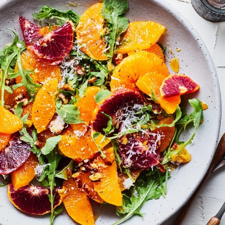 Freshly assembled Winter Citrus & Candied Pecan Salad, ready to eat, with crunchy pecans and goat cheese.
