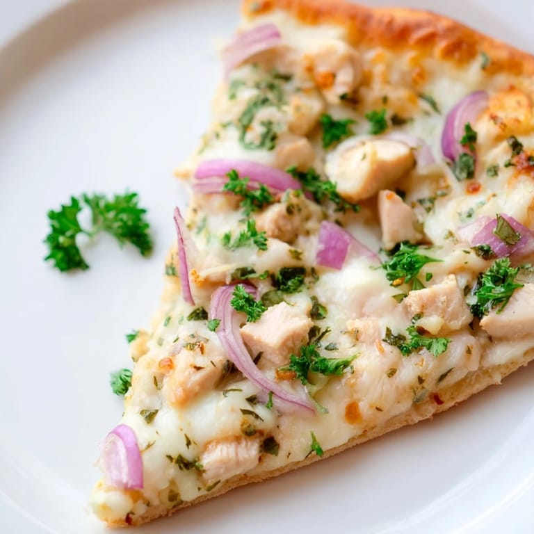 Freshly baked Chicken Alfredo Pizza with bubbly cheese and golden edges, ready to slice and serve hot.