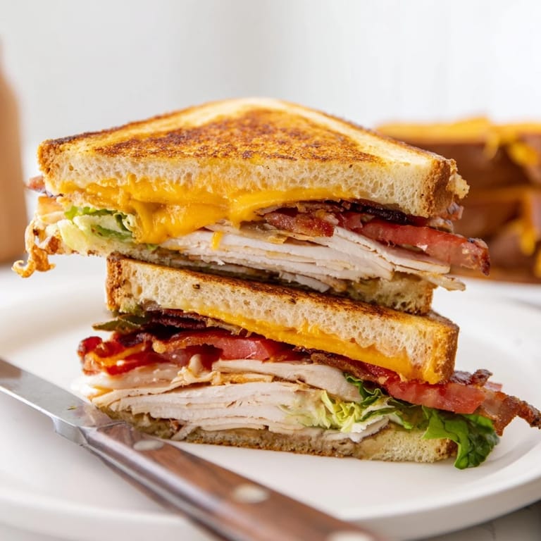Serve this hearty Turkey Club Grilled Cheese with a side of tomato soup for a comforting, classic American lunch experience.
