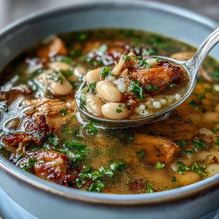 Creamy white bean and smoked turkey soup simmered with thyme, rosemary, and parsley for a comforting, aromatic meal.